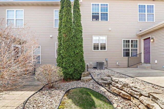 back of property featuring entry steps, a patio, and central AC