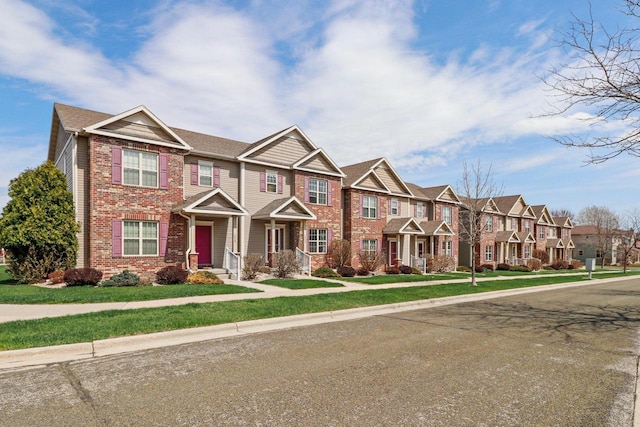 view of property with a residential view, a front yard, and brick siding