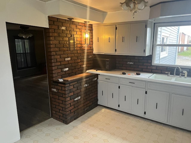 5169 Kratz Rd, Omro, WI 54963 - kitchen with light countertops, brick wall, and a sink