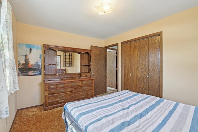 carpeted bedroom featuring baseboards and a closet