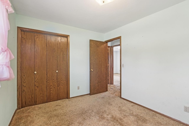 unfurnished bedroom featuring baseboards, a closet, and carpet