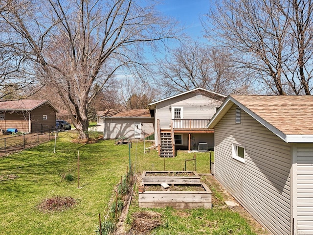 view of yard with a garden, stairway, fence, central air condition unit, and a wooden deck
