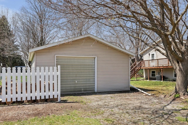 detached garage featuring fence and cooling unit