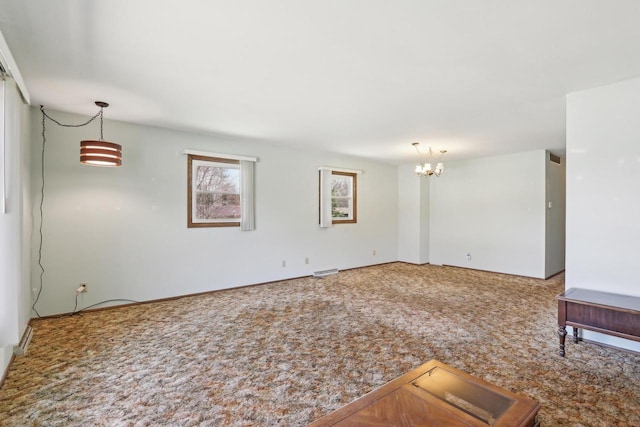 unfurnished living room with a chandelier, visible vents, and carpet flooring