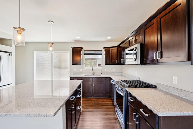1059 Okeeffe Ave, Sun Prairie, WI 53590 - kitchen featuring appliances with stainless steel finishes, a sink, dark brown cabinetry, light stone countertops, and dark wood-style flooring