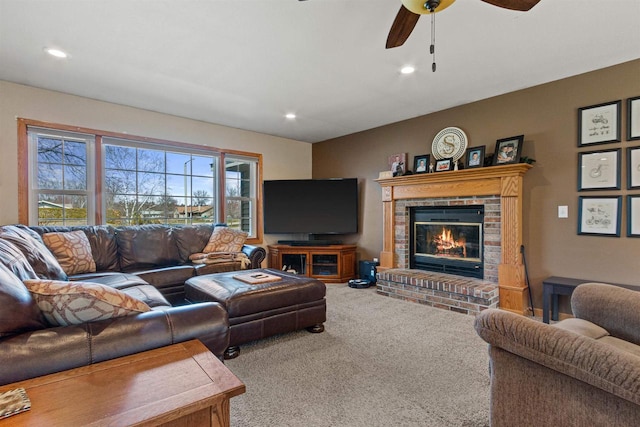 living room with recessed lighting, carpet, a brick fireplace, and a ceiling fan