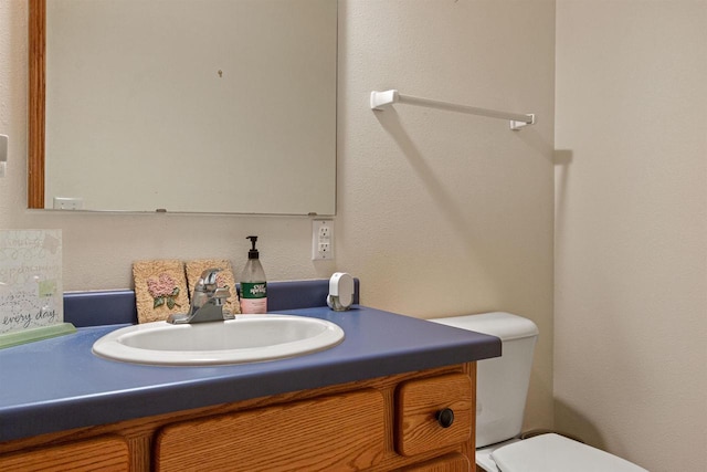 half bathroom featuring vanity and toilet