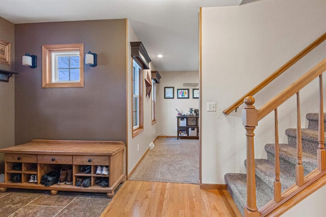 interior space featuring baseboards, wood finished floors, and stairs