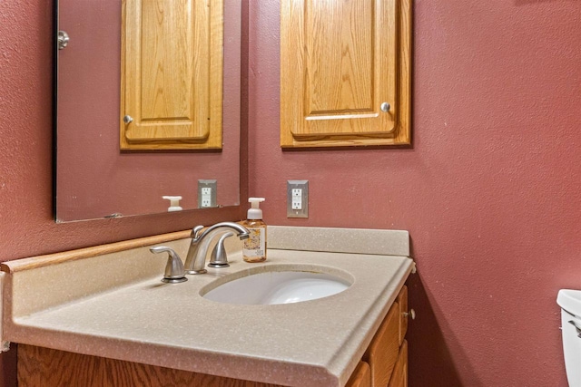 bathroom with a textured wall and vanity