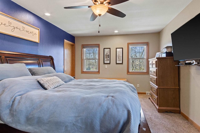 carpeted bedroom featuring baseboards, a ceiling fan, and multiple windows