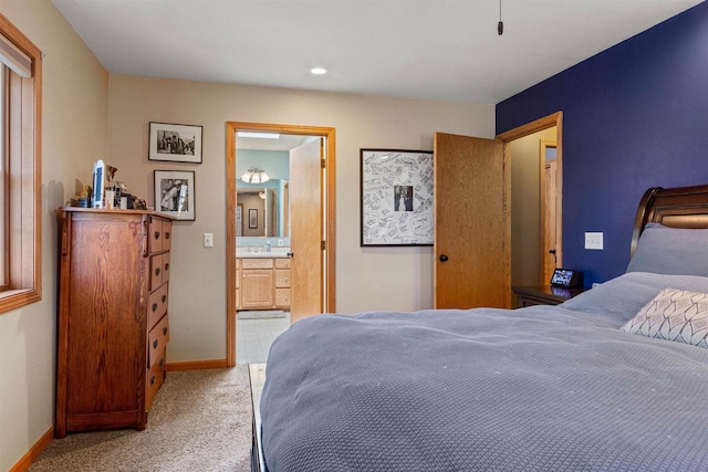 bedroom with recessed lighting, baseboards, ensuite bath, and light colored carpet