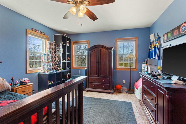 carpeted bedroom with ceiling fan and multiple windows
