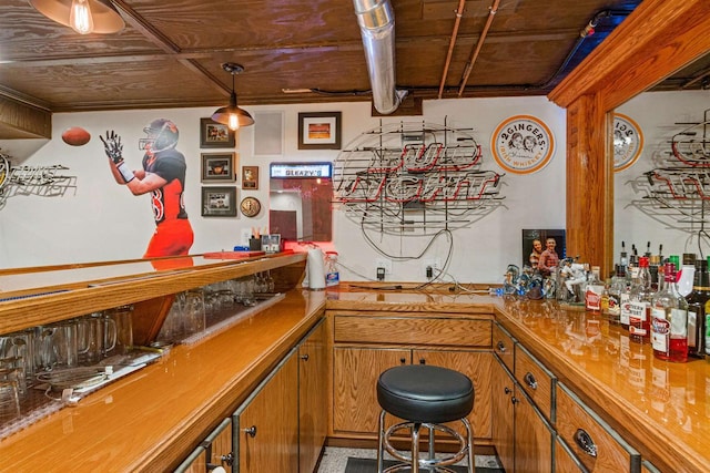 bar with decorative light fixtures and wet bar