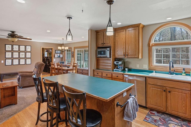 kitchen with a sink, light wood-type flooring, stainless steel appliances, a kitchen island, and recessed lighting