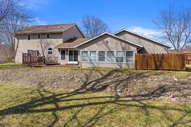 view of front of house with fence, a front yard, and a deck