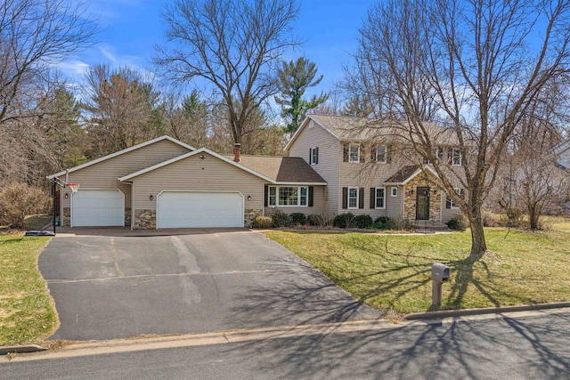 view of front of house featuring an attached garage, aphalt driveway, stone siding, and a front yard