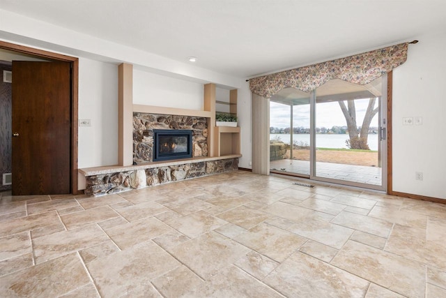 2151 Sunrise Dr, Appleton, WI 54914 - unfurnished living room featuring stone tile flooring, a water view, visible vents, baseboards, and a stone fireplace