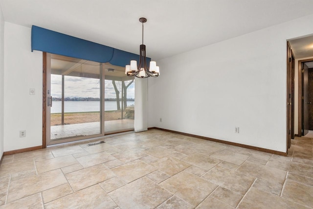 2151 Sunrise Dr, Appleton, WI 54914 - unfurnished room with a notable chandelier, baseboards, stone tile flooring, and a water view
