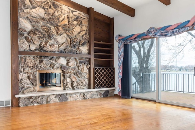 2151 Sunrise Dr, Appleton, WI 54914 - unfurnished living room with wood finished floors, visible vents, beam ceiling, and a wealth of natural light