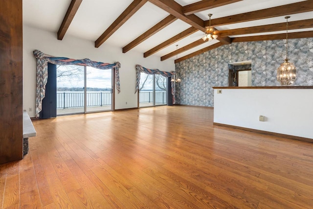 2151 Sunrise Dr, Appleton, WI 54914 - unfurnished living room with wallpapered walls, ceiling fan with notable chandelier, lofted ceiling with beams, wood-type flooring, and baseboards
