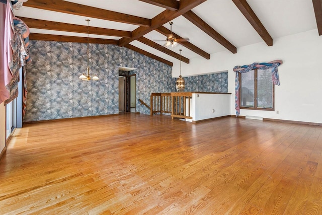 2151 Sunrise Dr, Appleton, WI 54914 - unfurnished living room with vaulted ceiling with beams, baseboards, wallpapered walls, a ceiling fan, and wood finished floors