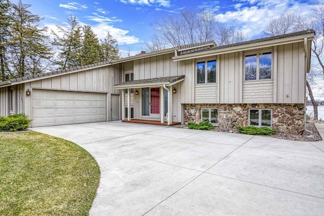 2151 Sunrise Dr, Appleton, WI 54914 - view of front of house featuring an attached garage, stone siding, and driveway