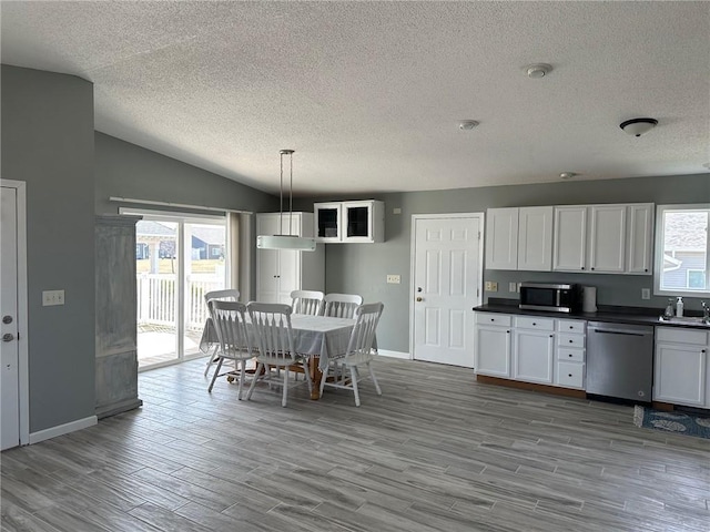 948 Wissota Green Pkwy, Chippewa Falls, WI 54729 - kitchen with stainless steel appliances, a textured ceiling, dark countertops, baseboards, and wood finished floors