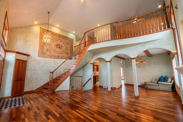 201 E Clearfield Ln, Appleton, WI 54913 - unfurnished living room with wood finished floors, high vaulted ceiling, a chandelier, arched walkways, and stairway