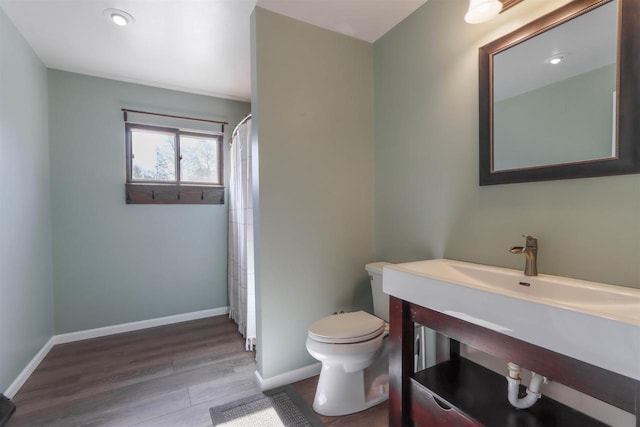 317 Darby Ct, Nekoosa, WI 54457 - bathroom with curtained shower, wood finished floors, toilet, vanity, and baseboards