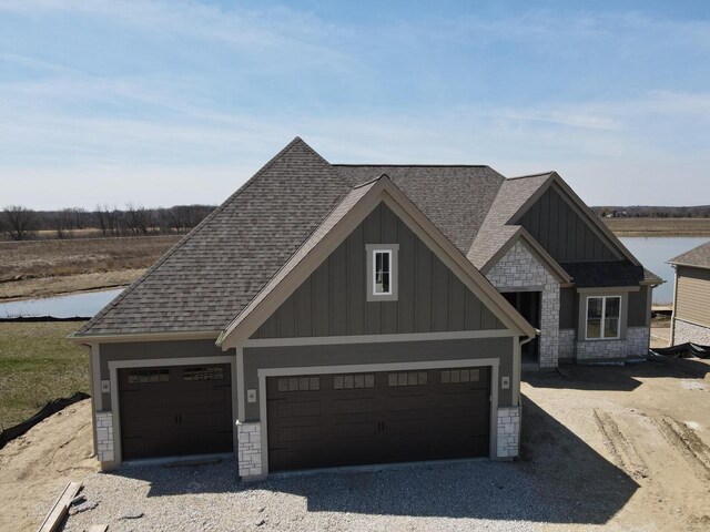 1618 White Deer Trl, Waukesha, WI 53189 - view of front of property with board and batten siding, gravel driveway, roof with shingles, and stone siding