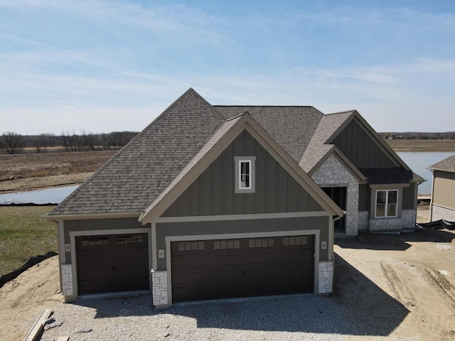 1618 White Deer Trl, Waukesha, WI 53189 - view of front of property with board and batten siding, gravel driveway, roof with shingles, and stone siding