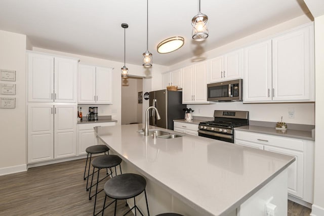 430 Ashley Dr, Williams Bay, WI 53191 - kitchen featuring a sink, stainless steel appliances, white cabinetry, a kitchen bar, and dark wood-style flooring