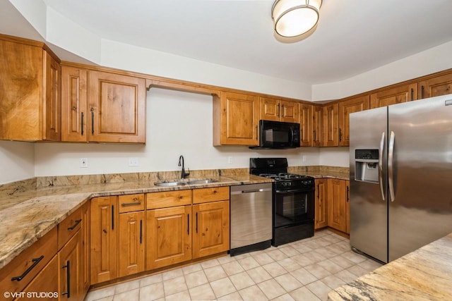 110 W St Unit 1, Lake Geneva, WI 53147 - kitchen with brown cabinets, light stone counters, light tile patterned floors, a sink, and black appliances