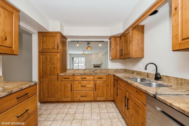 110 W St Unit 1, Lake Geneva, WI 53147 - kitchen featuring light stone counters, a sink, brown cabinetry, dishwasher, and rail lighting