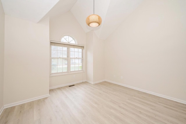 110 W St Unit 1, Lake Geneva, WI 53147 - spare room featuring visible vents, baseboards, wood finished floors, and lofted ceiling