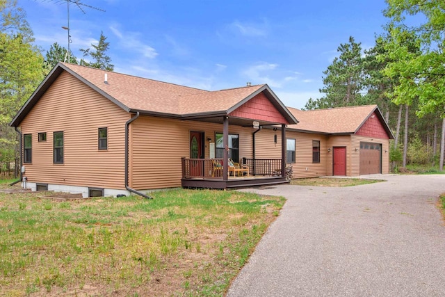 1686 Archer Ave, Nekoosa, WI 54457 - ranch-style home with roof with shingles, a porch, an outbuilding, asphalt driveway, and a garage