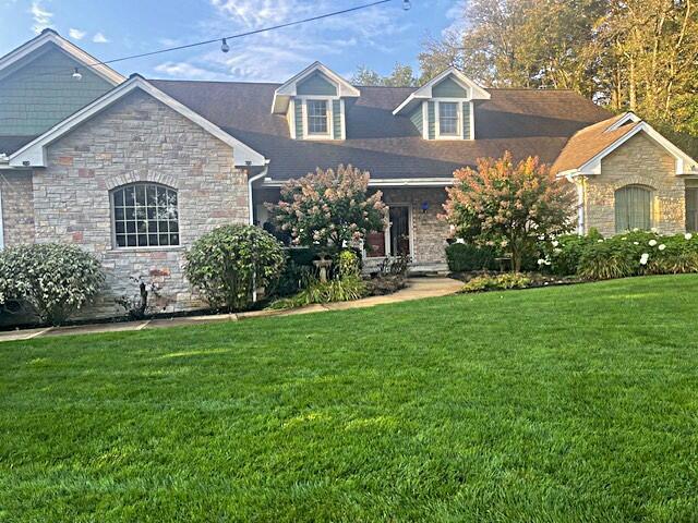 view of front of property featuring stone siding and a front lawn