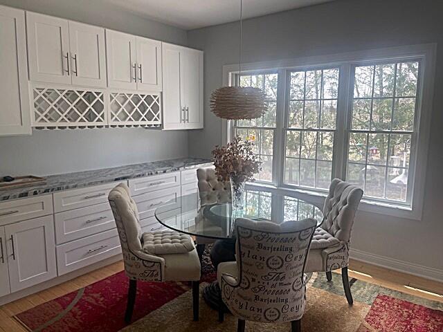 dining area with baseboards and light wood-type flooring