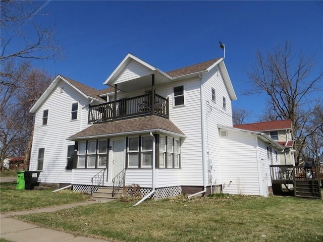 traditional-style house with entry steps, a front lawn, a balcony, and central AC unit