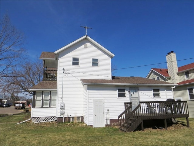 back of property featuring a lawn, a wooden deck, and roof with shingles