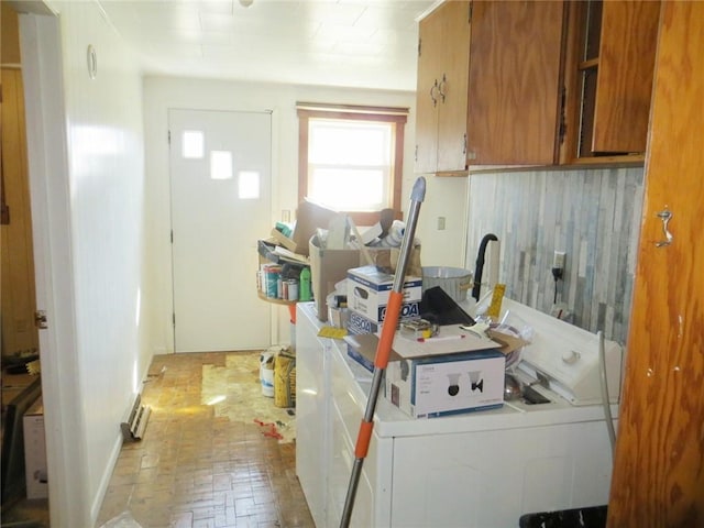 kitchen with separate washer and dryer, brick floor, and brown cabinetry