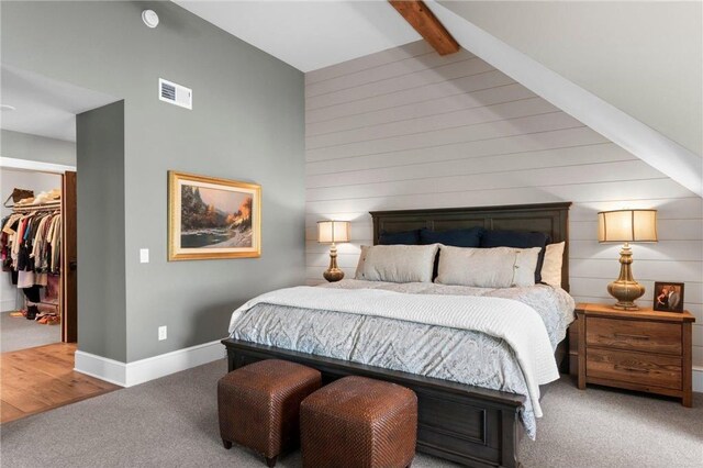 1211 172nd Ave, Balsam Lake, WI 54810 - carpeted bedroom featuring a walk in closet, beamed ceiling, high vaulted ceiling, a closet, and wooden walls