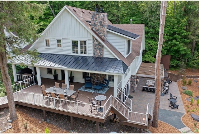 1211 172nd Ave, Balsam Lake, WI 54810 - rear view of property featuring board and batten siding, outdoor dining space, a deck, a metal roof, and a patio area