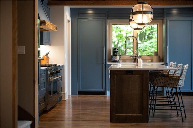 1211 172nd Ave, Balsam Lake, WI 54810 - kitchen featuring exhaust hood, double oven range, dark wood finished floors, light countertops, and a kitchen breakfast bar