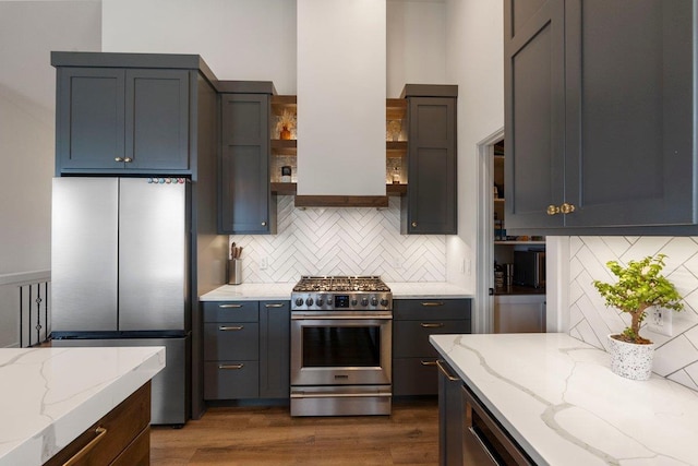 kitchen with backsplash, appliances with stainless steel finishes, open shelves, and light stone counters