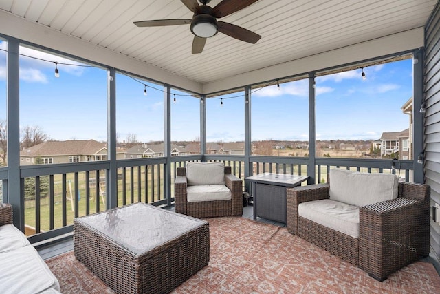 sunroom / solarium with ceiling fan, outdoor lounge area, and a residential view