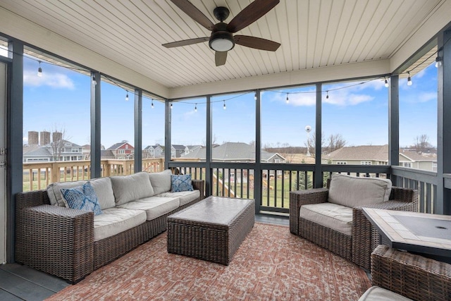 sunroom / solarium featuring ceiling fan, an outdoor hangout area, and a residential view