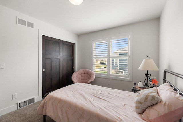 carpeted bedroom featuring baseboards, visible vents, and a closet