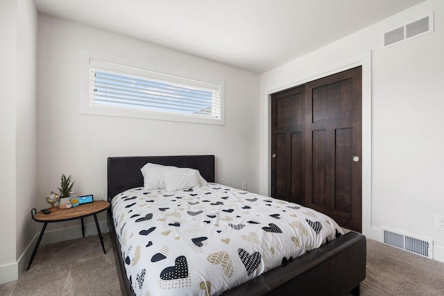 bedroom featuring a closet, carpet floors, visible vents, and baseboards