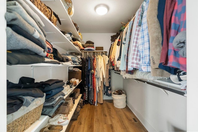 walk in closet with wood finished floors